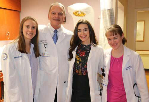 Mark Dykowski, M.D., with three of the OUWB students he delivered.